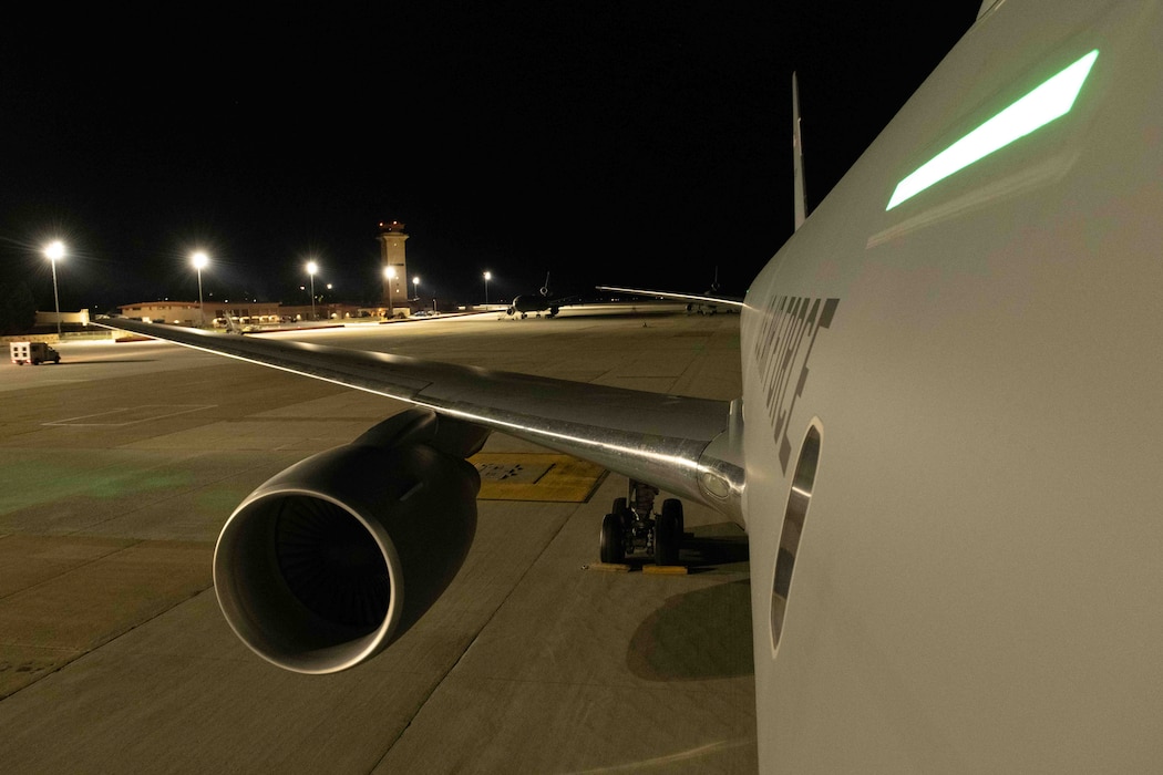 A KC-46A Pegasus aircraft sits on the flightline at night.