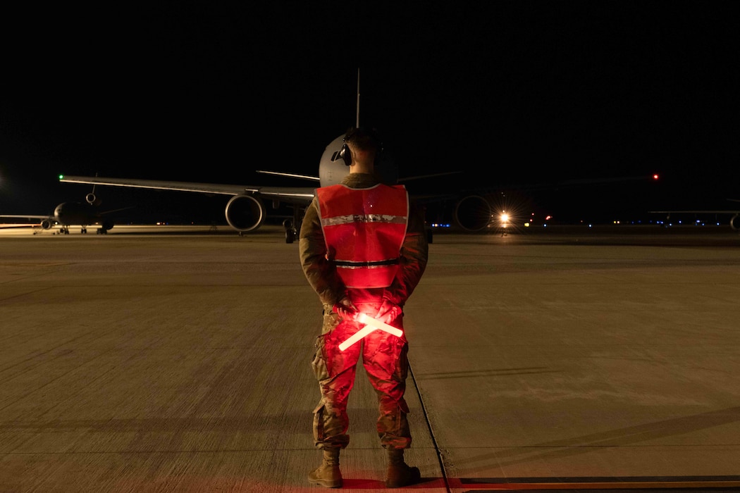 An Airman prepares to marshal a KC-46 to the taxiway