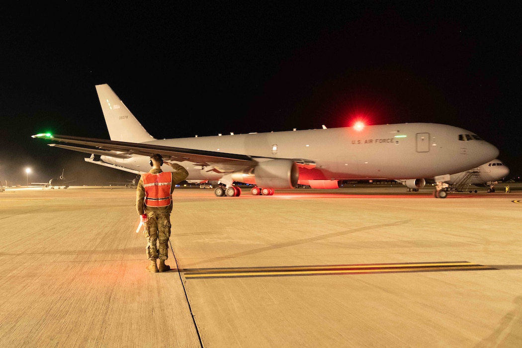 A KC-46 taxis to the runway at night.