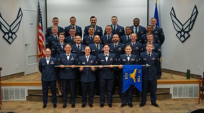 Airmen standing in dress blues in formation.