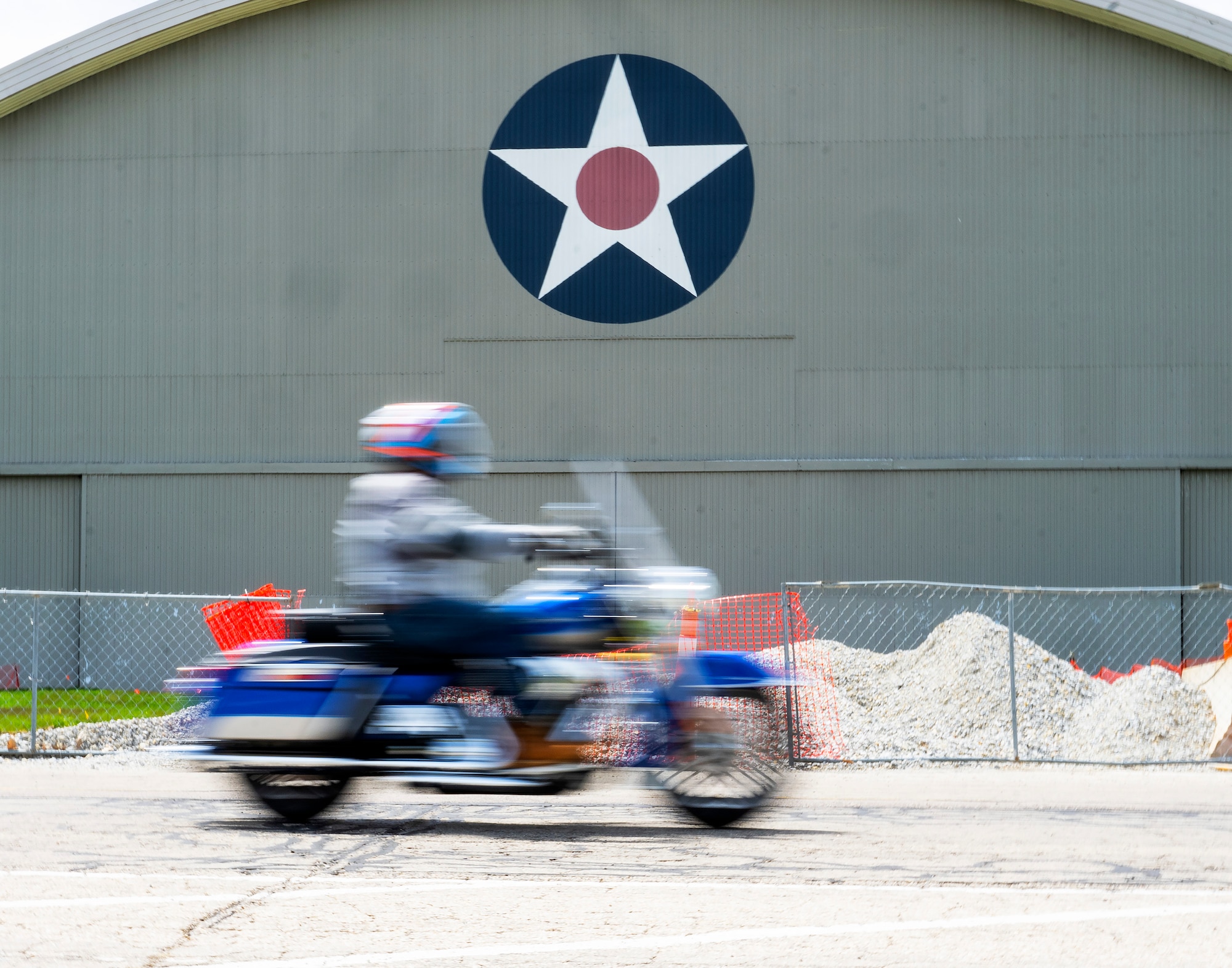 A motorcycle and rider are a blur of motion as they pass the Air Force Museum.