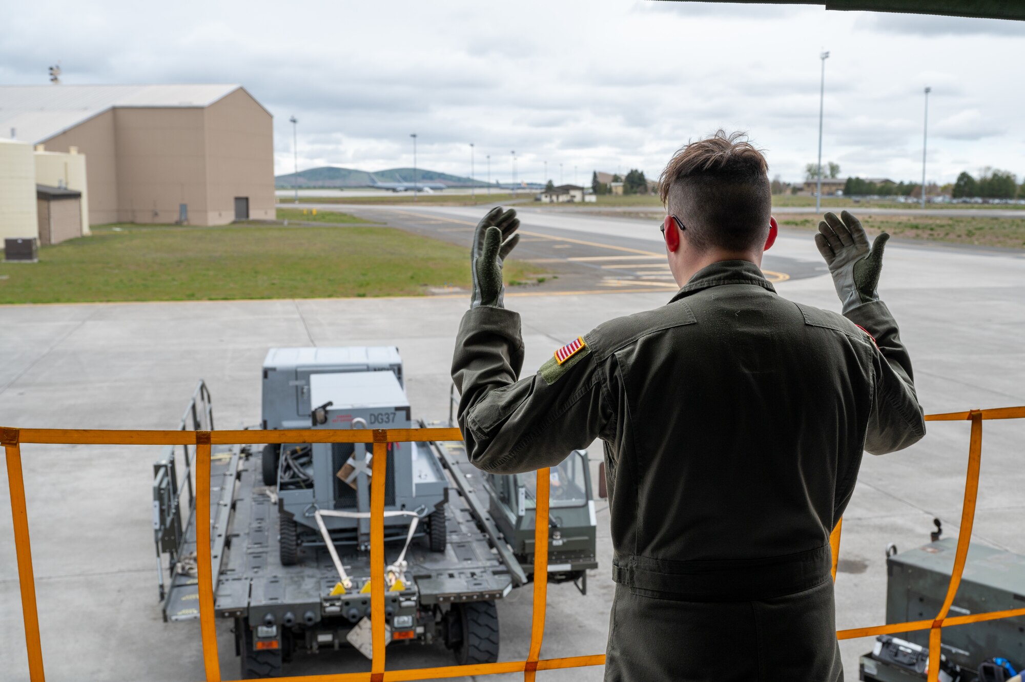 A servicemember guides a truck backing up