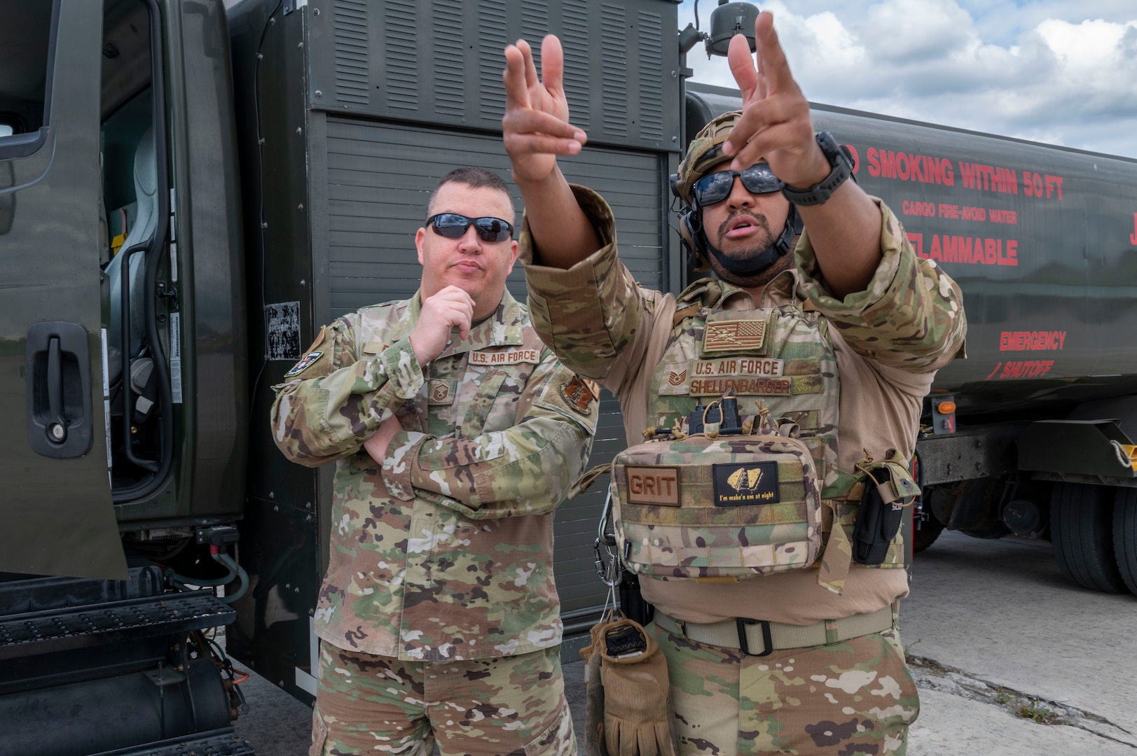 two men stand beside a fuel truck