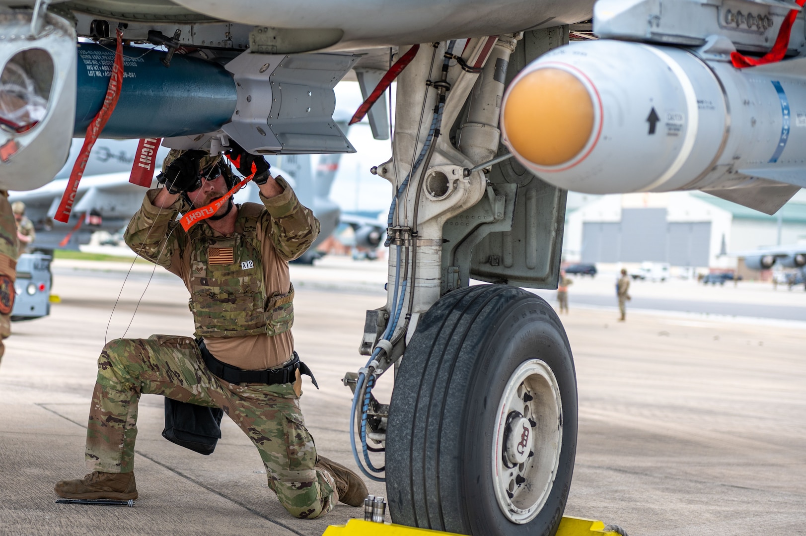 a man kneels under an aircraft