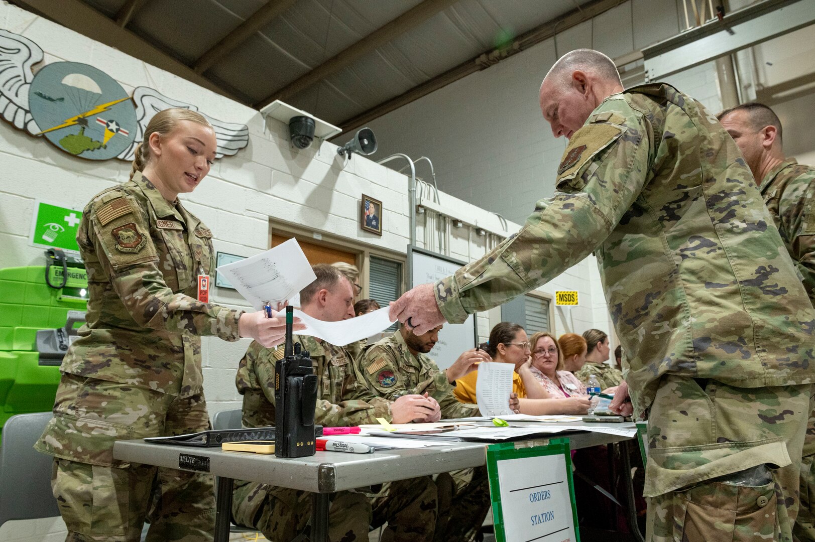 a woman hands a man a piece of paper