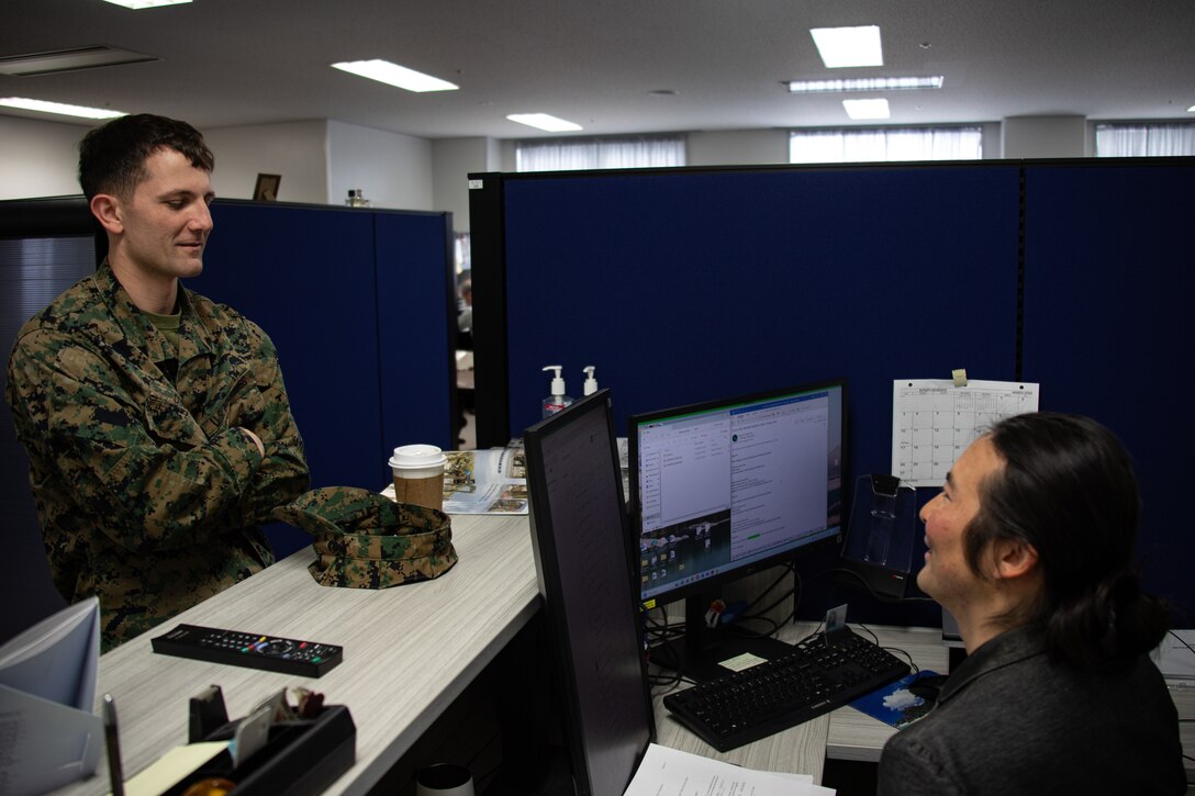 U.S. Marine Corps Cpl. Jacob Coby, a financial management resource analyst with Headquarters and Headquarters Squadron, Marine Corps Air Station Iwakuni, talks with Eisuke Koga, an administrative specialist with the comptroller department, at MCAS Iwakuni, Japan, March 21, 2024. Coby, a native of Lake Forest, California, continuously seeks self-improvement through education and physical and mental health. (U.S. Marine Corps photo by Lance Cpl. Rylan Adcock)