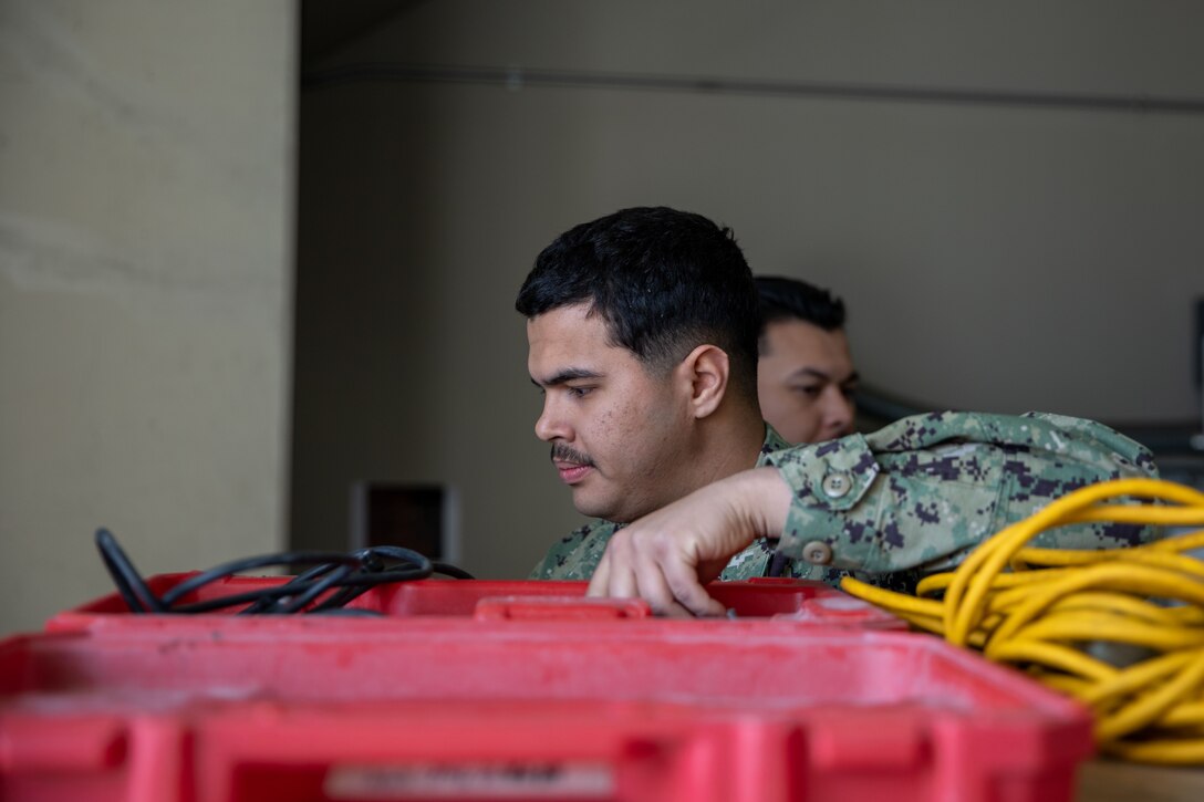 U.S. Navy Seaman Apprentice Jyvan Marquez-Fontanez, a Seabee with Headquarters & Headquarters Squadron, Marine Corps Air Station Iwakuni, gathers equipment during a drilling job at MCAS Iwakuni, Japan, March 22, 2024. The Seabees of MCAS Iwakuni are able to complete a variety of construction tasks, from installing furniture to repairing the airfield. Seaman Apprentice Jyvan Marquez-Fontanez is a native of Puerto Rico. (U.S. Marine Corps photo by Lance Cpl. Colin Thibault)