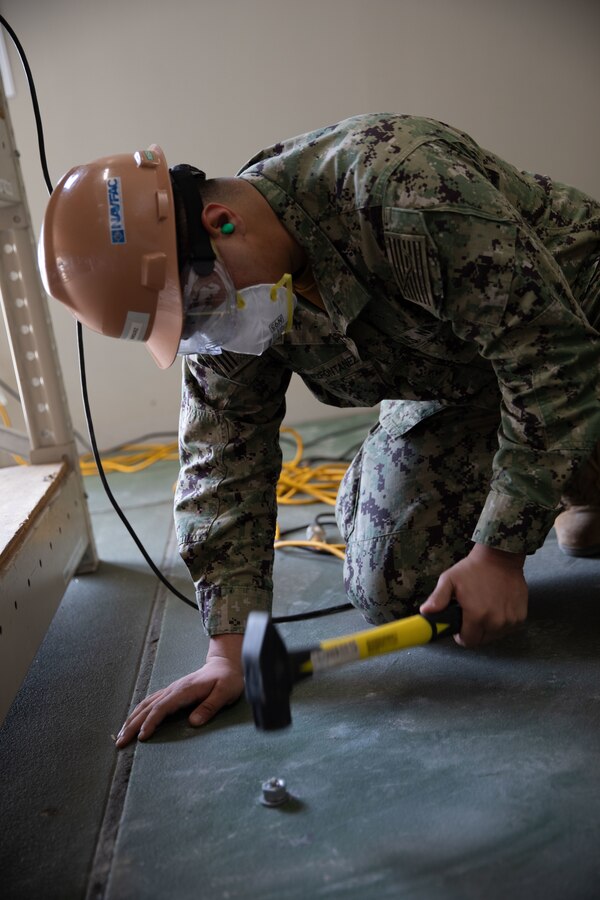 U.S. Navy Seaman Apprentice Jyvan Marquez-Fontanez, a Seabee with Headquarters & Headquarters Squadron, Marine Corps Air Station Iwakuni, secures an anchor bolt for shelving installation at MCAS Iwakuni, Japan, March 22, 2024. The Seabees of MCAS Iwakuni are able to complete a variety of construction tasks, from installing furniture to repairing the airfield. Seaman Apprentice Jyvan Marquez-Fontanez is a native of Puerto Rico. (U.S. Marine Corps photo by Lance Cpl. Colin Thibault)
