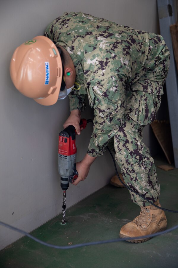 U.S. Navy Seaman Apprentice Jyvan Marquez-Fontanez, a Seabee with Headquarters & Headquarters Squadron, Marine Corps Air Station Iwakuni, drills into the floor to install shelving anchors at MCAS Iwakuni, Japan, March 22, 2024. The Seabees of MCAS Iwakuni are able to complete a variety of construction tasks, from installing furniture to repairing the airfield. Seaman Apprentice Jyvan Marquez-Fontanez is a native of Puerto Rico. (U.S. Marine Corps photo by Lance Cpl. Colin Thibault)