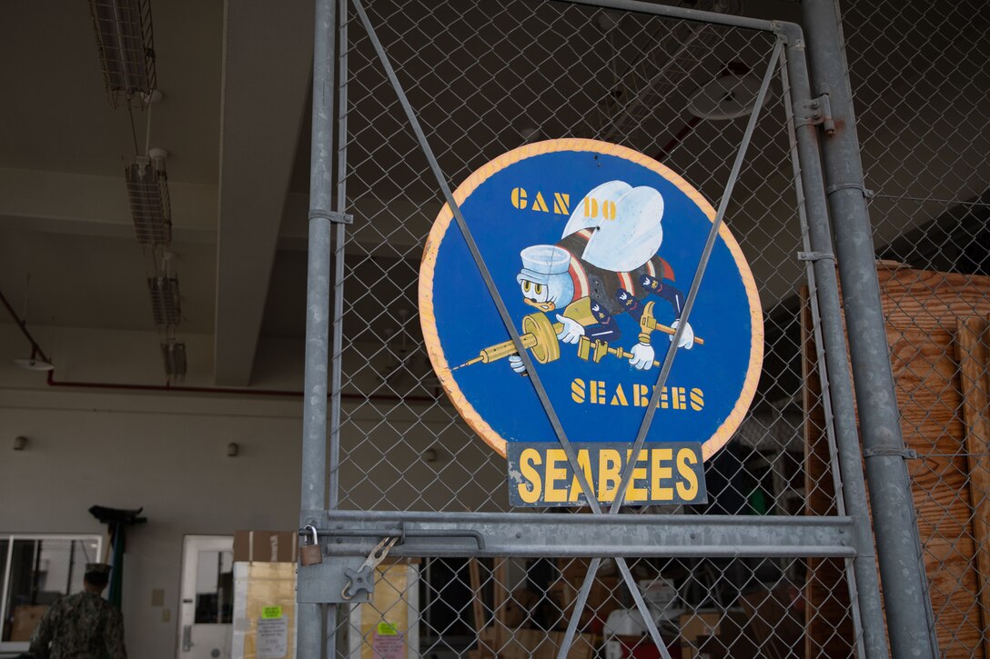 A metal circle painted with the emblem of the U.S. Navy Seabees outside the facilities building at Marine Corps Air Station Iwakuni, Japan, March 22, 2024. The Seabees of MCAS Iwakuni are able to complete a variety of construction tasks, from installing furniture to repairing the airfield. (U.S. Marine Corps photo by Lance Cpl. Colin Thibault)