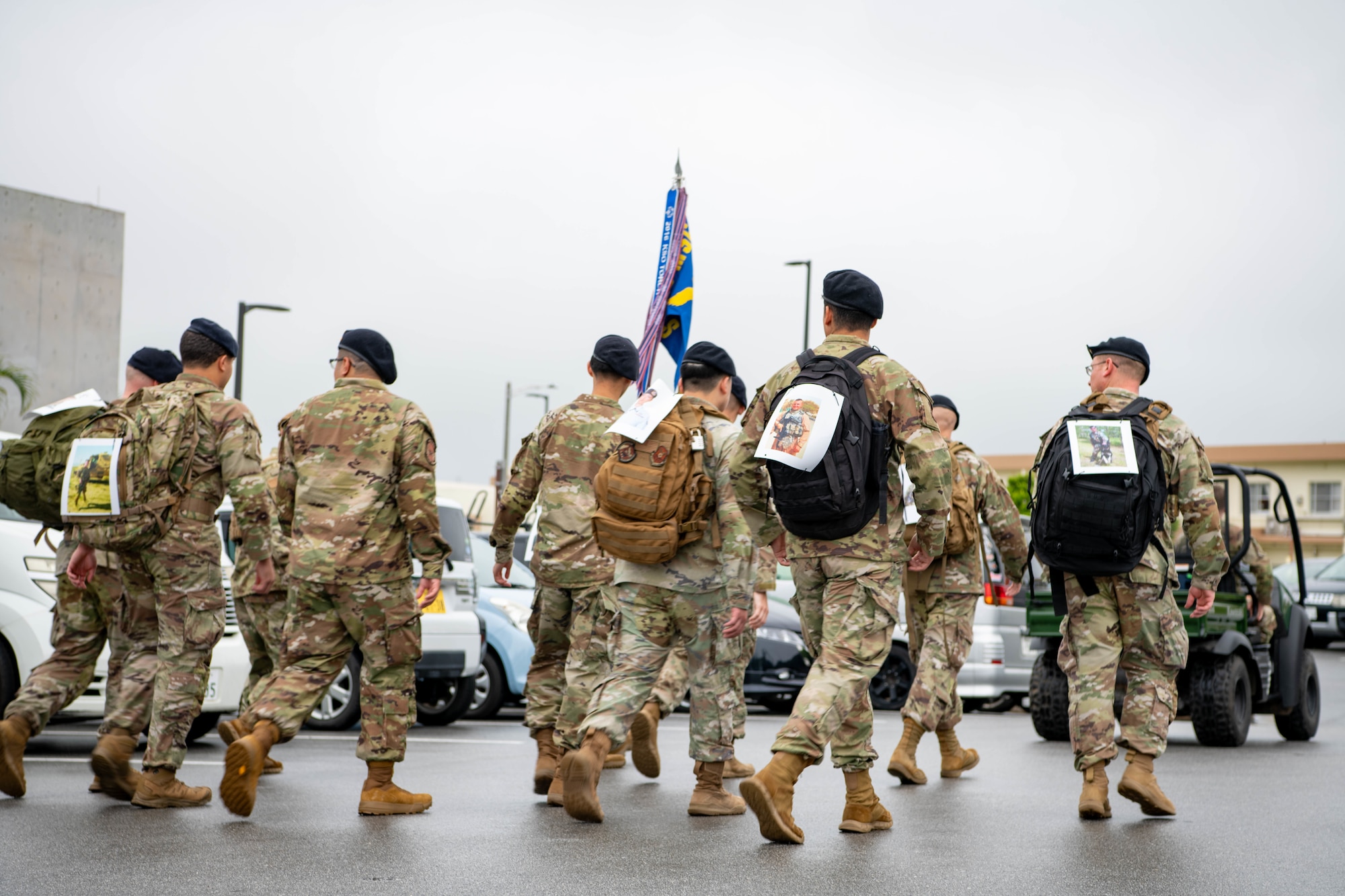 security forces members walk together with weighted backpacks
