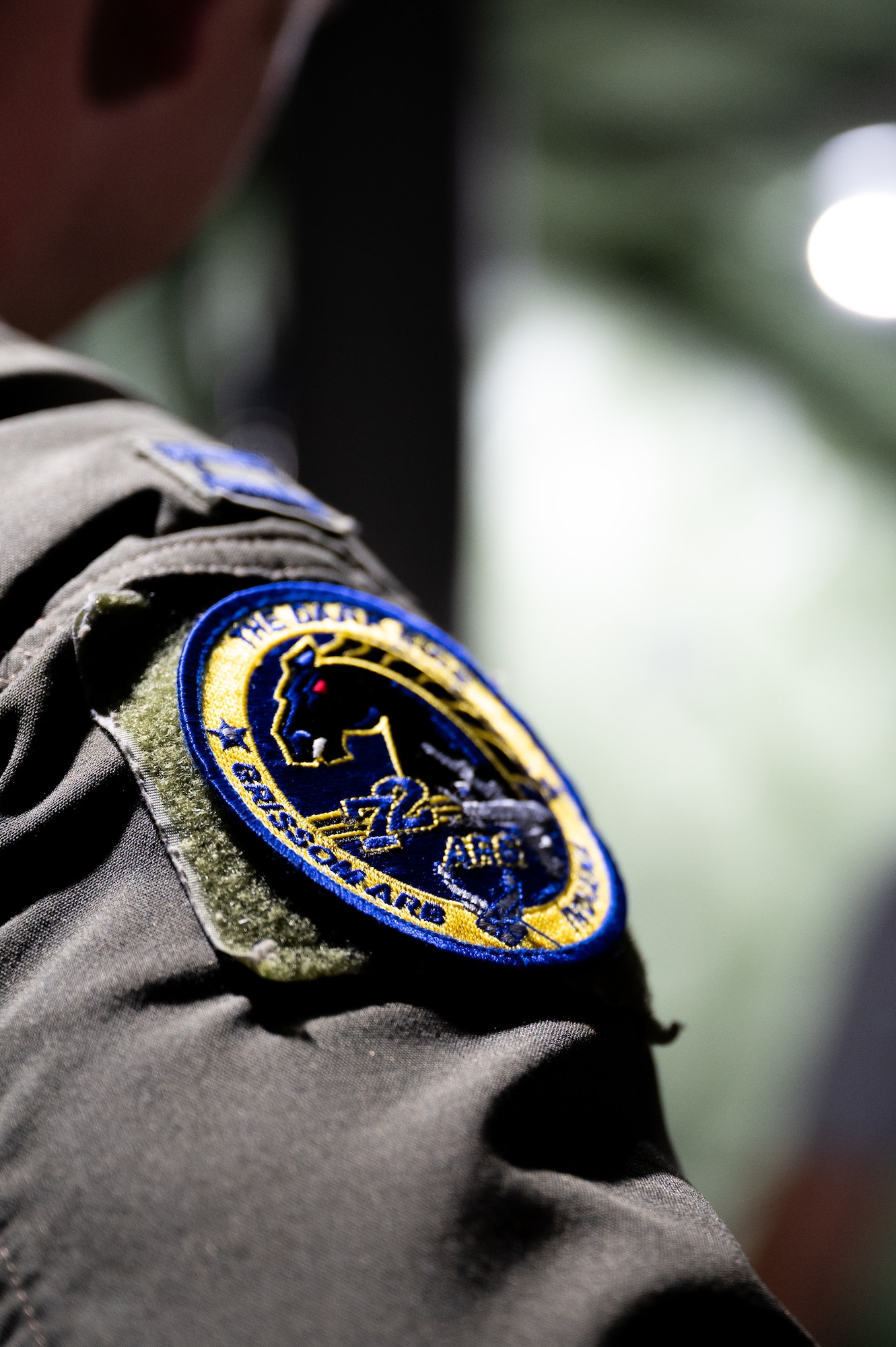 A patch, attached to the shoulder of a U.S. Air Force flight uniform, is visible.