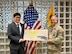 Army Soldier in uniform presents tuition check to future Army Medicine Professional