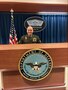 Army Soldier in official uniform stands behind Department of Defense seal in the Pentagon