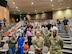 Four Army Soldiers in uniform stand with medical students in an auditorium