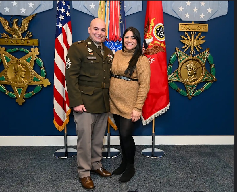 Army Soldier in uniform poses with his wife in the Hall of Heroes in the Pentagon