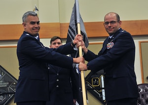 Maj. Joseph Calidonna, right, receives a gray flag from Lt. Col. Jaime Garcia during a ceremony at Malmstrom AFB, Montana, May 9, 2024. The ceremony signifies Maj. Calidonna accepting command of the 22nd Space Operations Squadron Detachment 1.