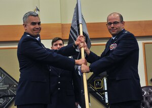 Maj. Joseph Calidonna, right, receives a gray flag from Lt. Col. Jaime Garcia during a ceremony at Malmstrom AFB, Montana, May 9, 2024. The ceremony signifies Maj. Calidonna accepting command of the 22nd Space Operations Squadron Detachment 1.