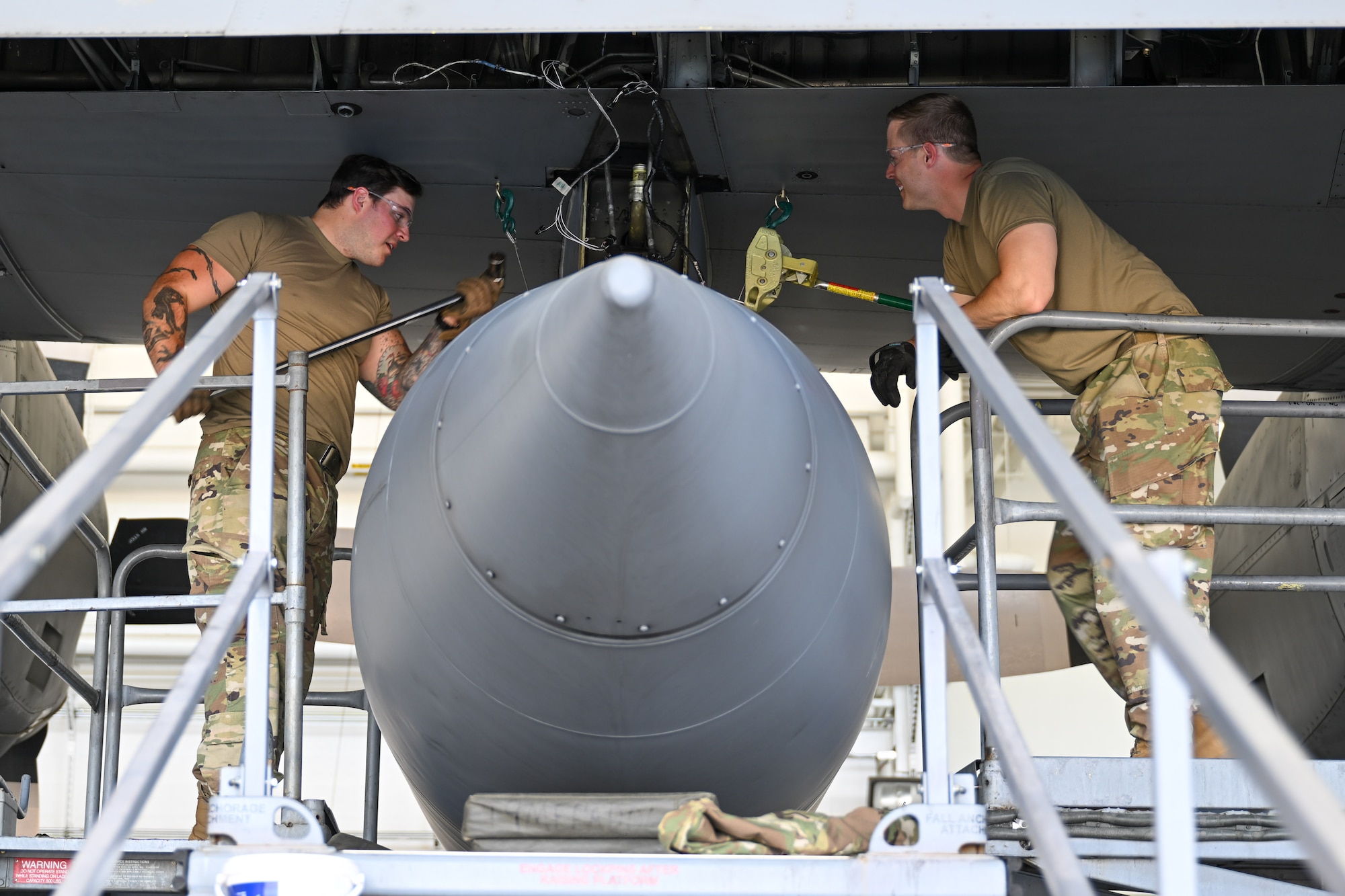 Master Sgt. Chad Conroy and Tech. Sgt. Dakota Perkins, aircraft fuel system craftsmen assigned to the 910th Maintenance Squadron, use a breaker bar to loosen the bolts that affix a fuel tank to the wing of a C-130H Hercules aircraft at Youngstown Air Reserve Station, Ohio, May 7, 2024.