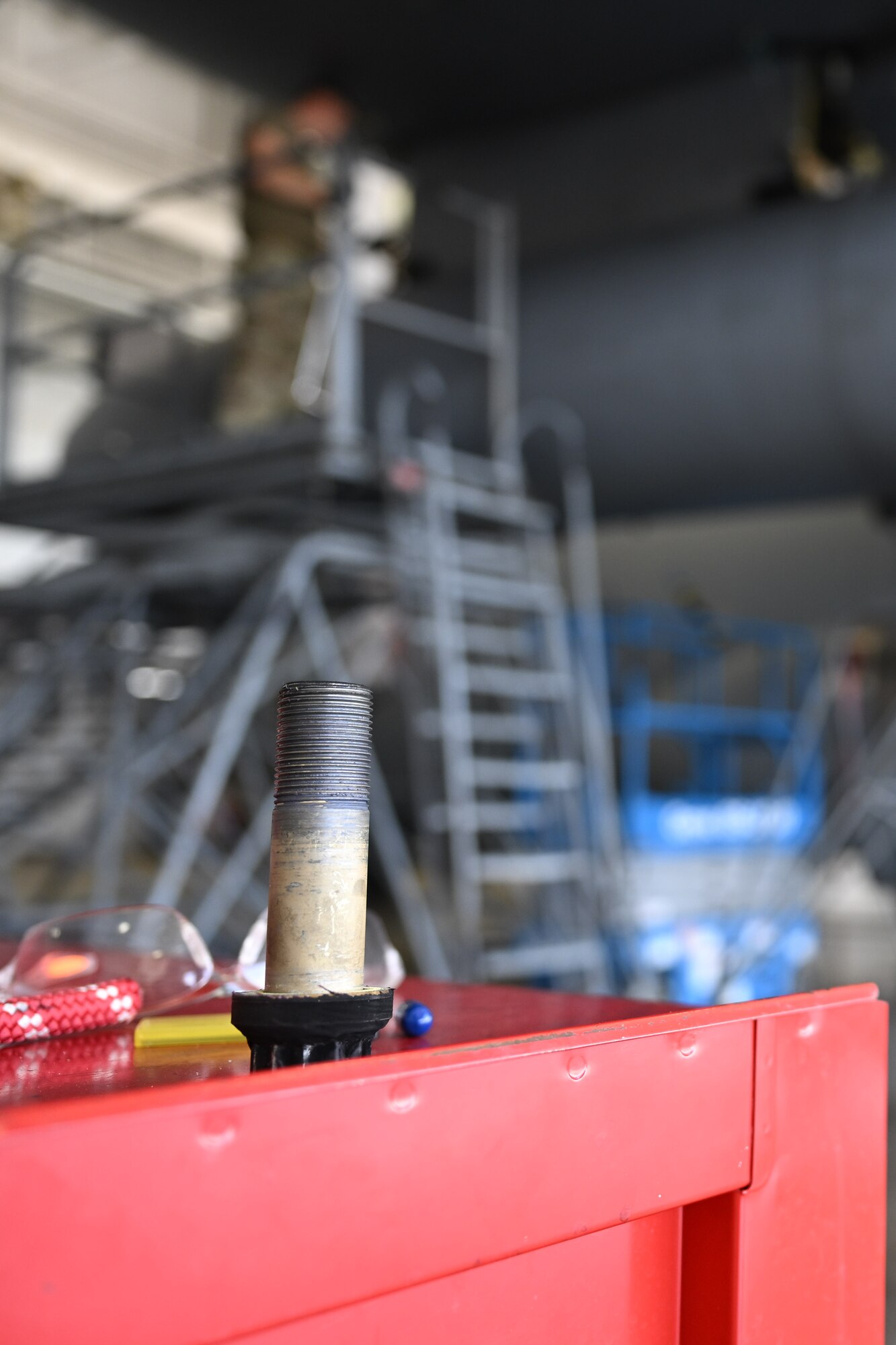 A removed bolt sits on a tool cart while members of the 910th Maintenance Squadron work to remove the other three bolts securing a fuel tank to the wing of a C-130H Hercules aircraft at Youngstown Air Reserve Station, Ohio, May 7, 2024.