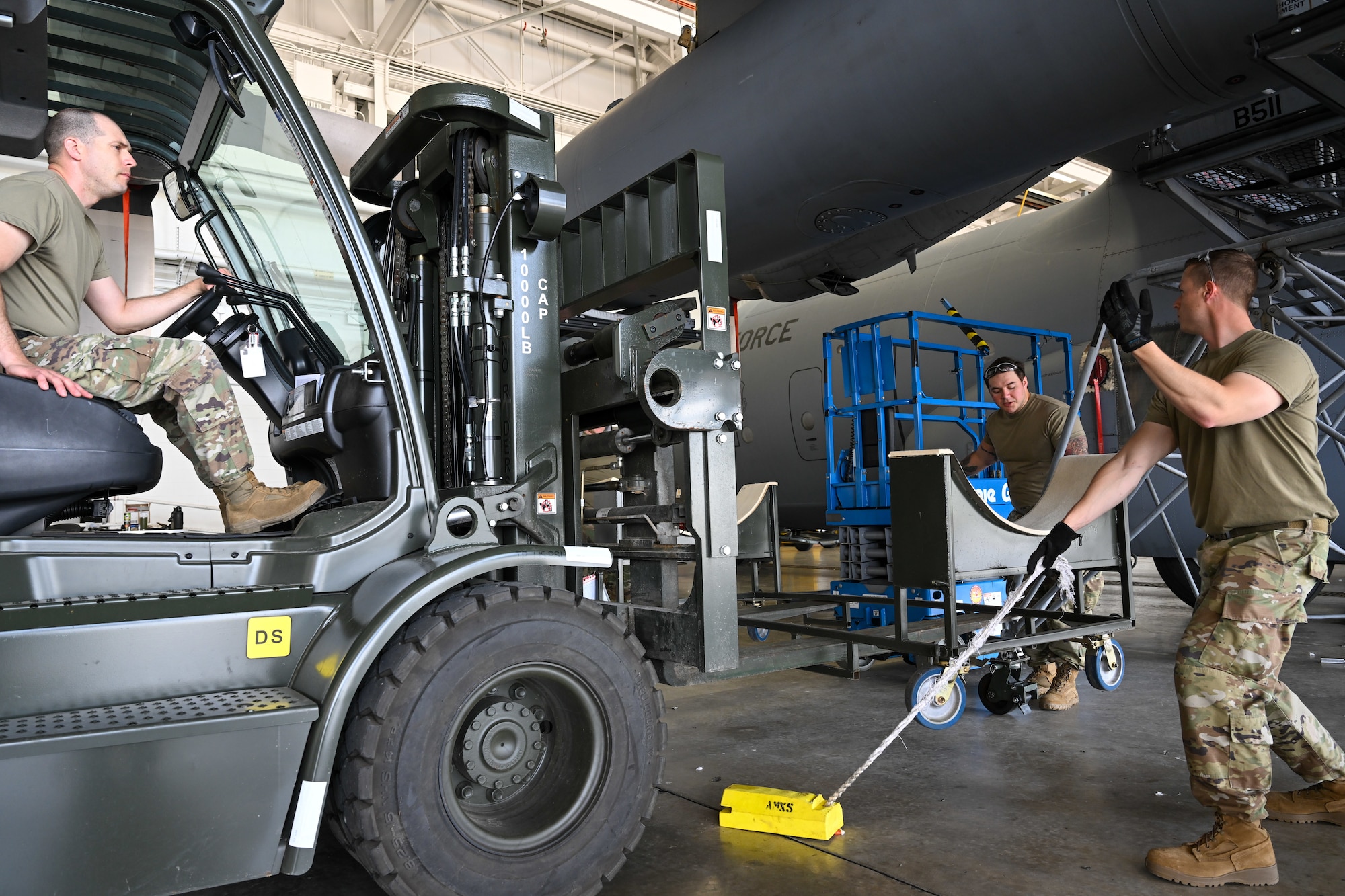 Master Sgt. Thaddeus Root steers a forklift carrying a fuel tank cart into place beneath the wing of a C-130H Hercules aircraft while Master Sgt. Chad Conroy directs at Youngstown Air Reserve Station, Ohio, May 7, 2024.