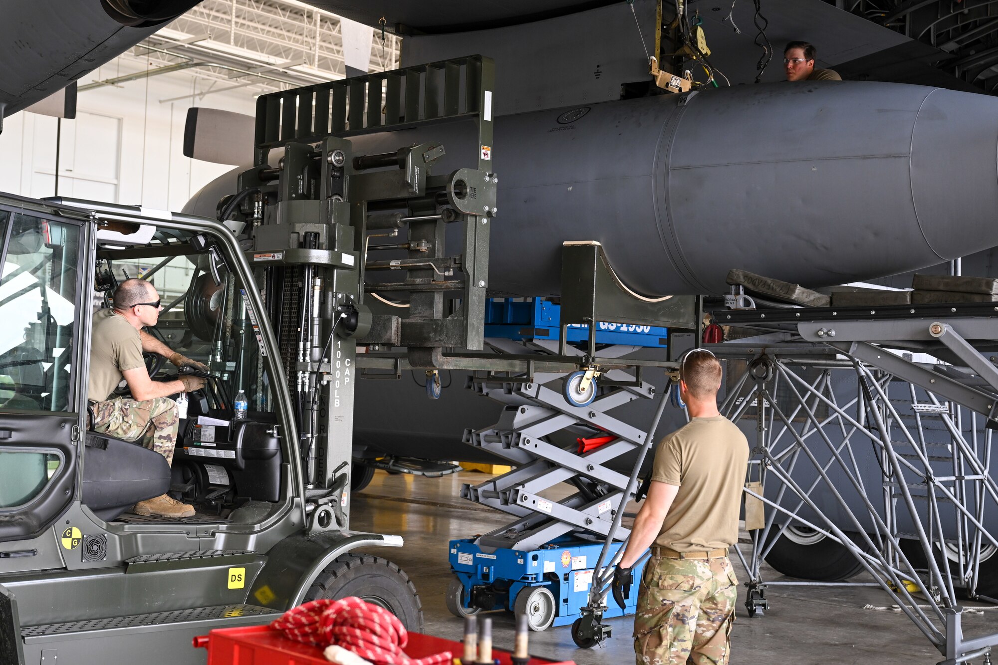 C-130H Hercules aircraft at Youngstown Air Reserve Station, Ohio, May 7, 2024, while Master Sgt. Thaddeus Root (left) and Master Sgt. Chad Conroy (bottom right) observe.