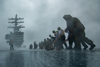 Sailors scrub the flight deck of USS Ronald Reagan (CVN 76).