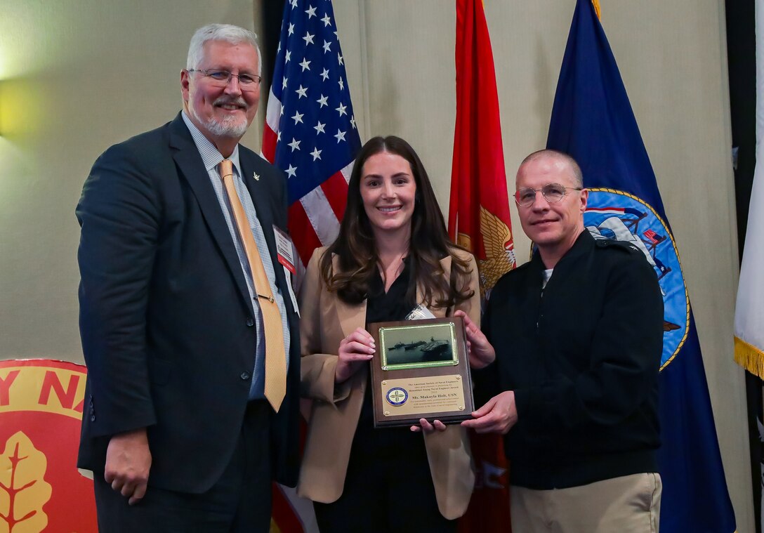 Vice Adm. David Lewis, USN (Ret.) and Chief Engineer and Deputy Commander for Ship Design, Integration and Naval Engineering, SEA-05, Naval Sea Systems Command Rear Adm. Jason Lloyd present the Rosenblatt Young Naval Engineer Award to NSWCPD’s Makayla Holt during the 2024 American Society of Naval Engineers (ASNE) Advanced Machinery Technology Symposium (AMTS), held at the Delta Hotel Philadelphia Airport in Philadelphia on May 1-2, 2024. (U.S. Navy Photo by Jay Butterbaugh/Released)