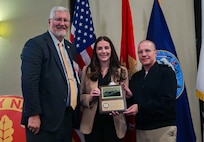 Vice Adm. David Lewis, USN (Ret.) and Chief Engineer and Deputy Commander for Ship Design, Integration and Naval Engineering, SEA-05, Naval Sea Systems Command Rear Adm. Jason Lloyd present the Rosenblatt Young Naval Engineer Award to NSWCPD’s Makayla Holt during the 2024 American Society of Naval Engineers (ASNE) Advanced Machinery Technology Symposium (AMTS), held at the Delta Hotel Philadelphia Airport in Philadelphia on May 1-2, 2024. (U.S. Navy Photo by Jay Butterbaugh/Released)