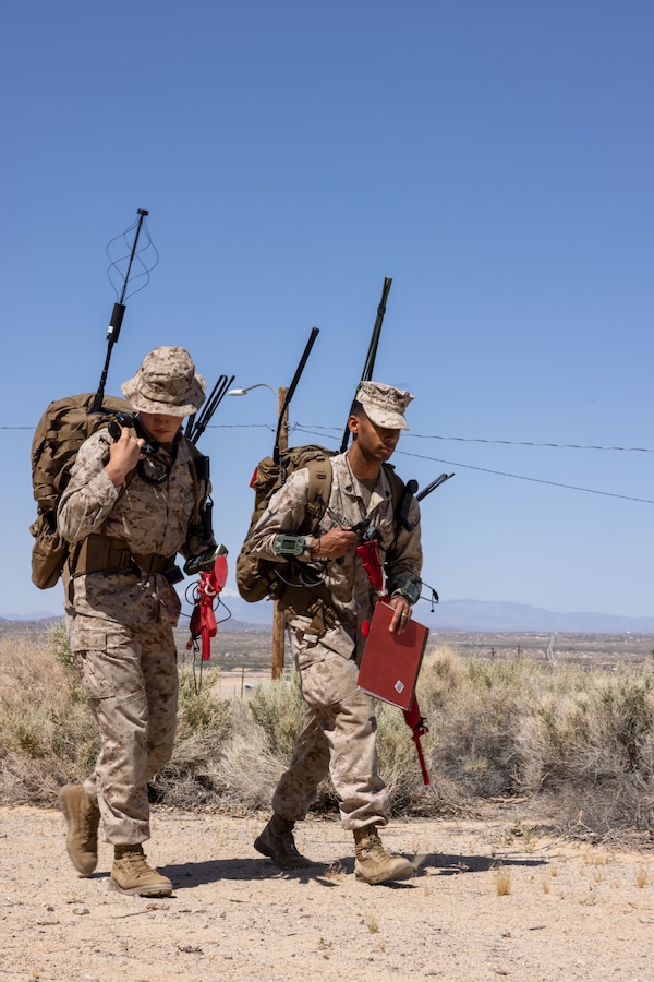 U.S. Marine Corps Cpl. Judson Skinner, a Double Springs, Alabama native, satellite transmissions system operator with Headquarters Battalion, Marine Wing Communications Squadron 18, 1st Marine Aircraft Wing, left, and Sgt. Ramal Holston, a Senoia, Georgia native, radio operator with 3rd Marine Littoral Regiment, 3d Marine Division, III Marine Expeditionary Force, hike during Expeditionary Communications Course 1-24 hosted by Marine Corps Communication-Electronics School at Marine Corps Air-Ground Combat Center, Twentynine Palms, California, May 2, 2024. ECC trains Marines in expeditionary skillsets that enable them to operate independently and to assemble various types of communication equipment in any environment across the full range of military operations. (U.S. Marine Corps photo by Lance Cpl. Anna Higman)