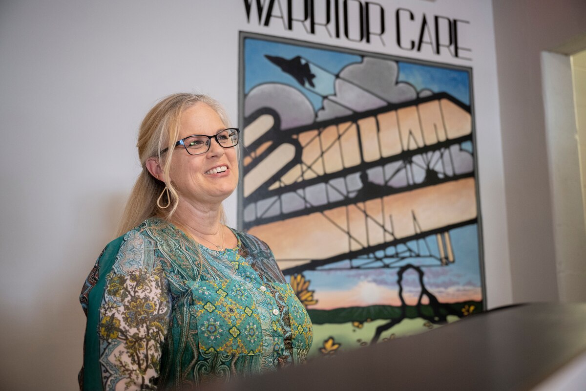 Female stands in front of mural.