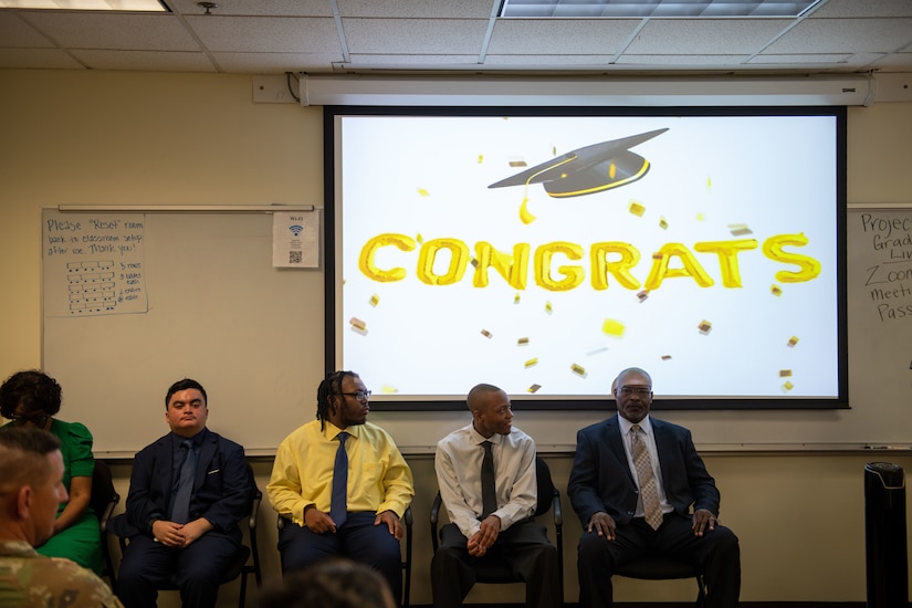 Graduates sit in a row.