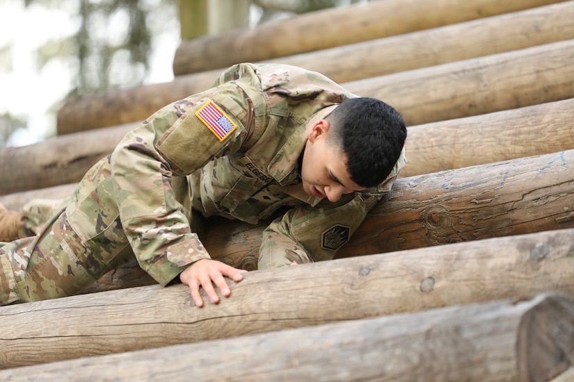 A soldier negotiates a wooden obstacle.