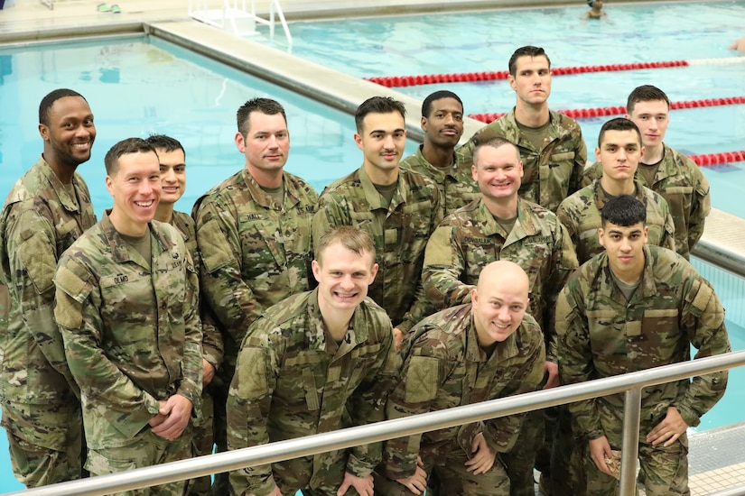A group of soldiers posing in front of a pool.