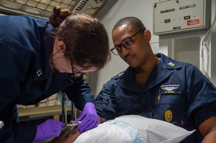 PHILIPPINE SEA (May 10, 2024) Command Master Chief Tychicious Turner, command master chief of the U.S. Navy’s only forward-deployed aircraft carrier, USS Ronald Reagan (CVN 76), has his blood drawn by Lt. Elizabeth Casey, ship’s nurse, from Anniston, Alabama, in the ship’s medical clinic for a walking blood bank screening aboard the U.S. Navy’s only forward-deployed aircraft carrier, USS Ronald Reagan (CVN 76), in the Tokyo Inlet May 10. Ronald Reagan, the flagship of Carrier Strike Group 5, provides a combat-ready force that protects and defends the United States, and supports alliances, partnerships and collective maritime interests in the Indo-Pacific region. (U.S. Navy photo by Mass Communication Specialist 3rd Class Eric Stanton)