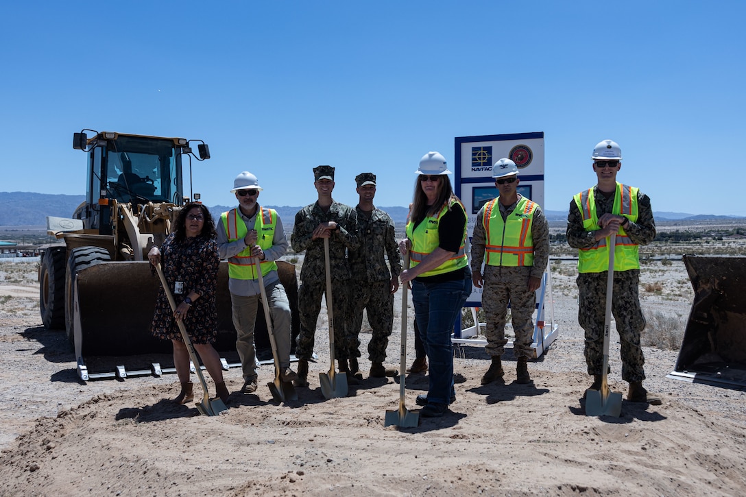 U.S. service members and ceremony guests pose for a photo in a groundbreaking ceremony for the new warfighting center at Marine Corps Air-Ground Combat Center, Twentynine Palms, California, May 7, 2024. The project consolidates training for the Marine Air-Ground Task Force Training Directorate and Tactical Training and Exercise Control Group by incorporating command and control of all operational force training with space for classified wargaming, modeling and simulation, exercise control, after action review, and secure operations to promote twenty-first century learning and facilitate Naval integration. (U.S. Marine Corps photo by Cpl. Josiah Jorgensen)