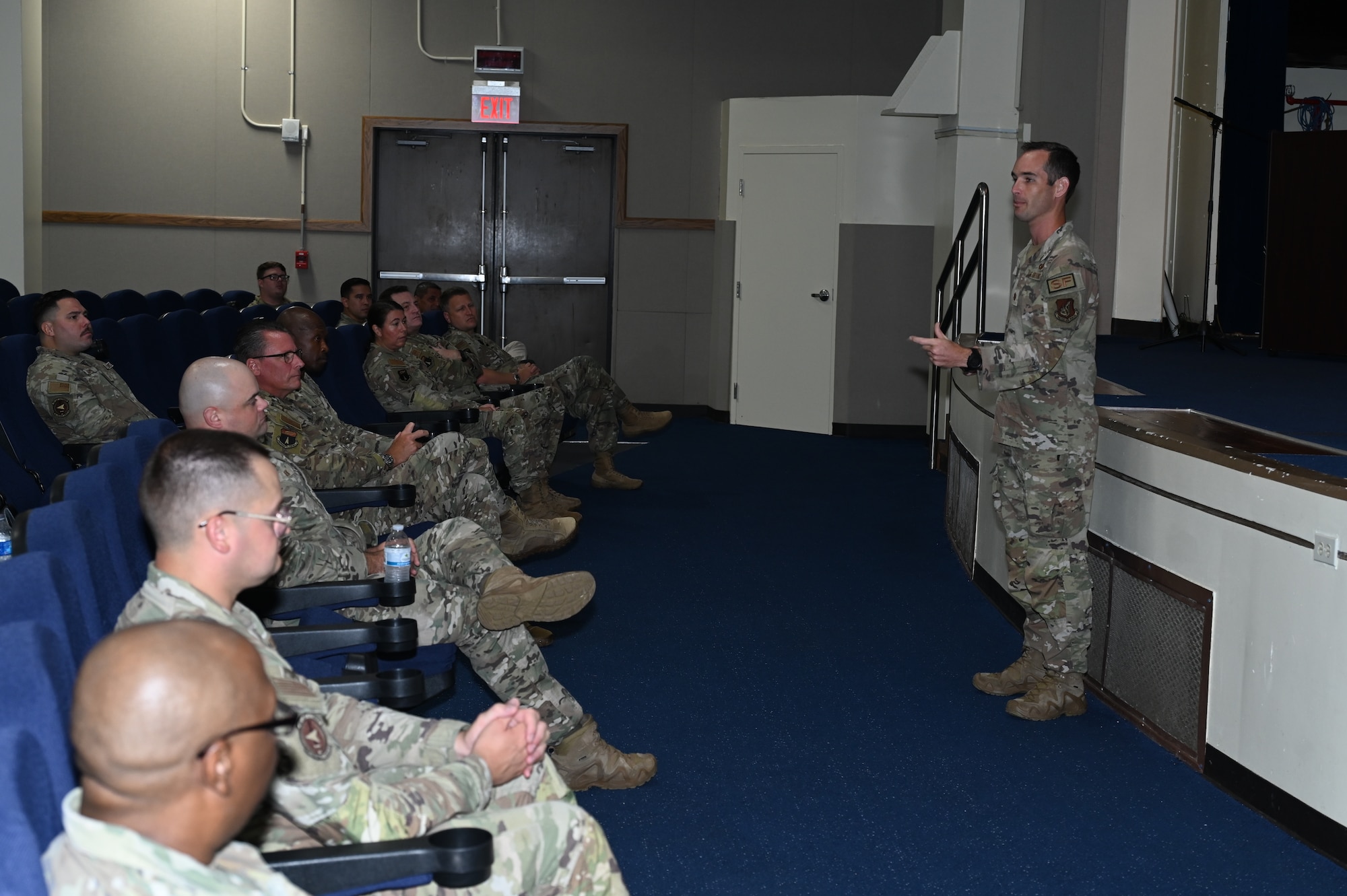 A 36th Security Forces Squadron commander stands in front of a stage and speak to his Airmen.