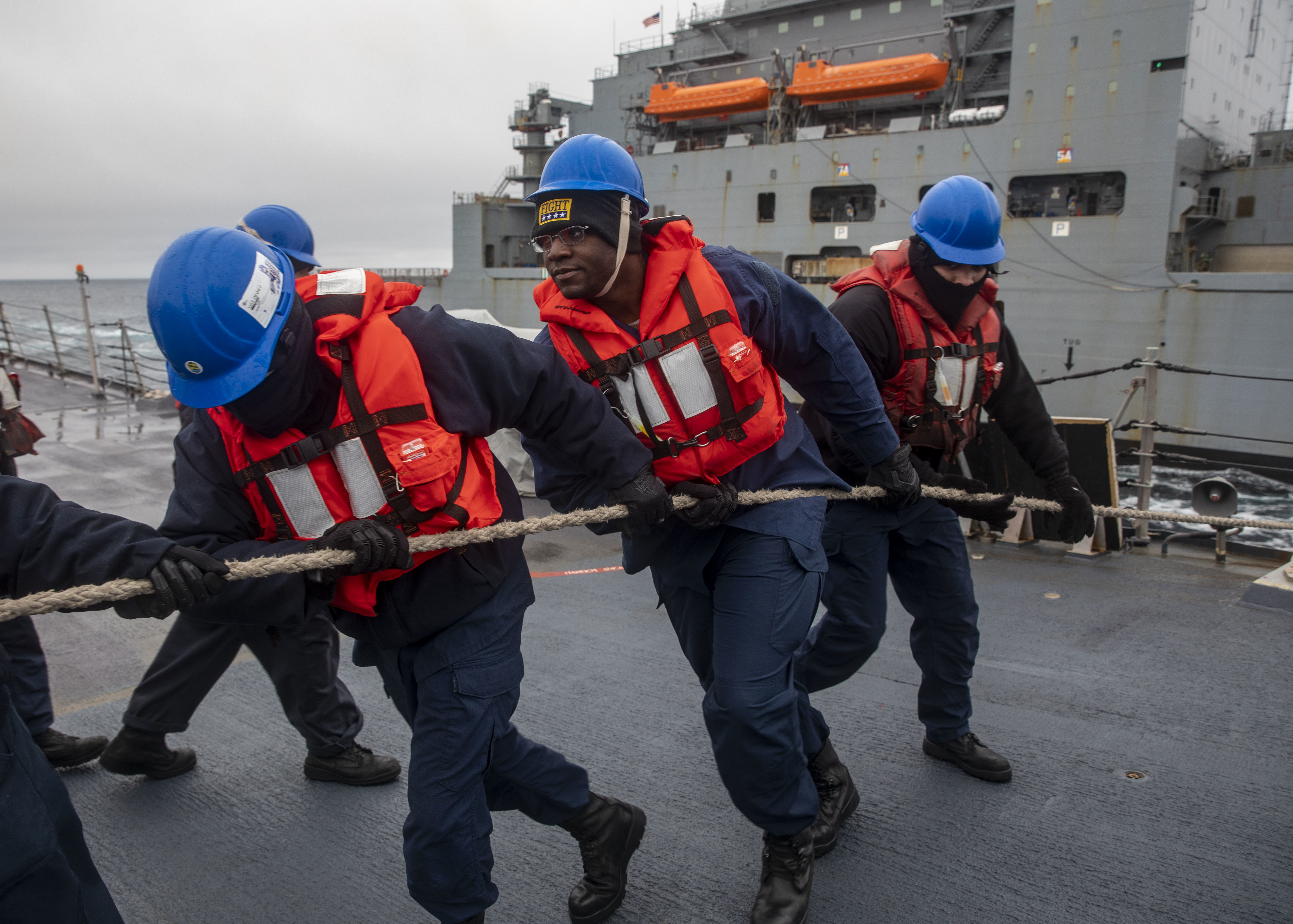 PACIFIC OCEAN (April 22, 2024) Sailors aboard the Arleigh Burke-class guided-missile destroyer USS Dewey (DDG 105) heave a line during a replenishment-at-sea with the Lewis and Clark-class dry-cargo ship USNS Cesar Chavez (T-AKE-14) while conducting operations in the north Pacific Ocean, April 22, 2024.
