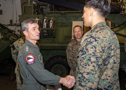 Vice Adm. Doug G. Perry, Commander, U.S. 2nd Fleet, left, speaks with Hospital Corpsman 2nd Class Robert Woods, during his visit to the amphibious assault ship USS Wasp (LHD 1), May 7, 2024.
