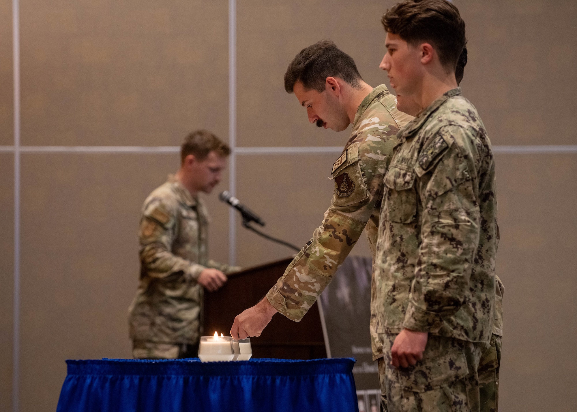 military member lights a candle