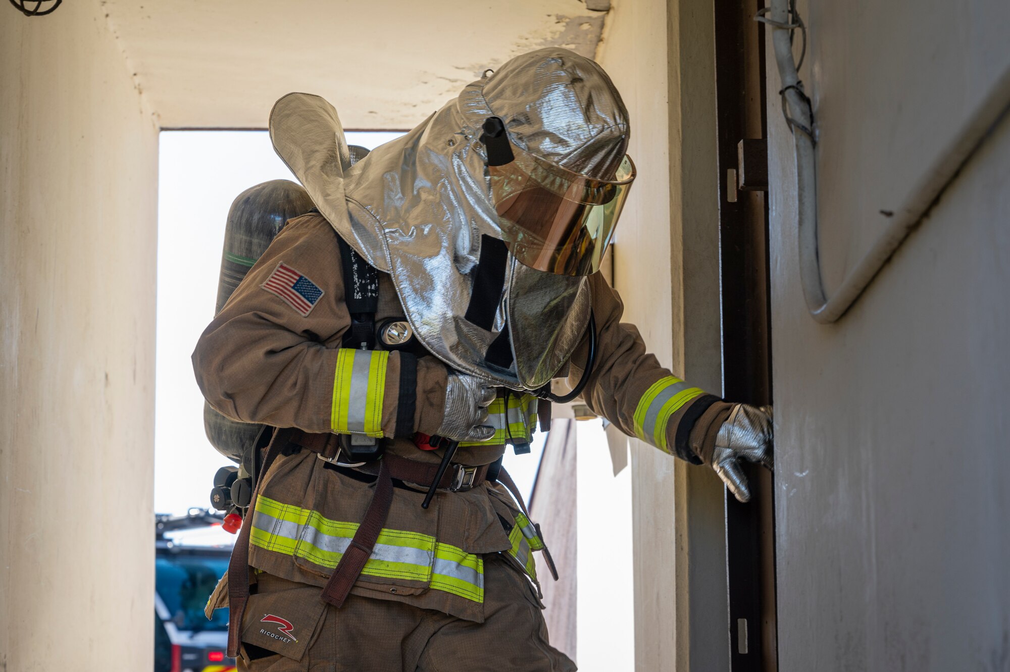 A U.S. Air Force firefighter assigned to the 51st Civil Engineer Squadron prepares to enter a hangar and extinguish a simulated fire during Beverly Herd 24-1 at Osan Air Base, Republic of Korea, May 13, 2024. The 51st CES rapid intervention team focused on locating the fire and any victims while simultaneously relaying information to incident command. Routine training events like BH 24-1 are pivotal platforms for 51st Fighter Wing Airmen to refine their warfighting proficiencies through practical application, concurrently enhancing their ability to respond skillfully to contingencies. (U.S. Air Force photo by Senior Airman Sabrina Fuller-Judd)
