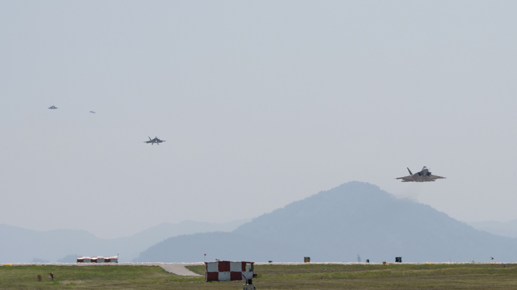 Four F-22 Raptor aircraft prepare to land at Kunsan Air Base.