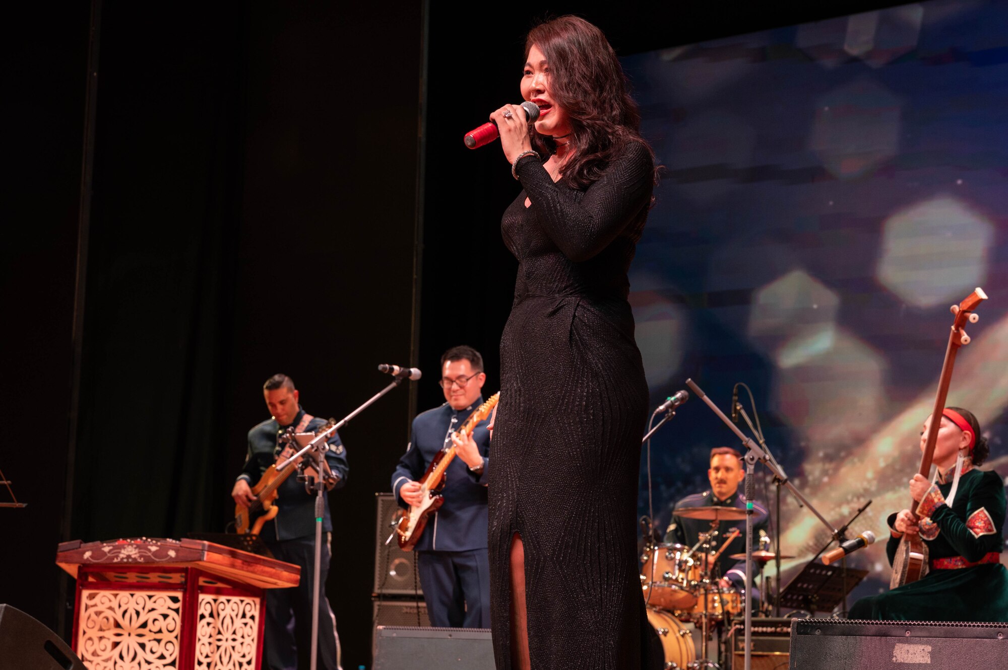 Woman sings with band in the back.