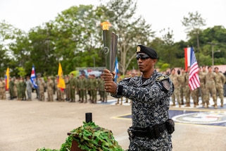 Panamanian 2nd Lt. Josué A. Juárez, a competitor, secures the lit torch to initiate the beginning of Fuerza Comando 24 during the opening ceremony in Cerro Tigre, Panama, May 13, 2024.