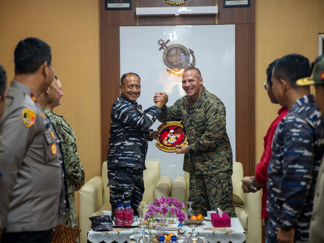 U.S. Marine Corps Col. Sean Dynan, commanding officer of the 15th Marine Expeditionary Unit gifts a 15th MEU plaque to Indonesian Navy (TNI-AL) Rear Adm. Yoos Suryono Hadi, commander of 1st Fleet Command, prior to the opening ceremony of Cooperation Afloat Readiness and Training (CARAT) Indonesia 24 in Bandar Lampung, Indonesia, May 13, 2024. This year marks the 30th iteration of CARAT, a multinational exercise series designed to enhance U.S. and partner navies' abilities to operate together in response to traditional and non-traditional maritime security challenges in the Indo-Pacific region. (U.S. Marine Corps photo by Sgt. Patrick Katz)