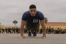 A U.S. Marine drill instructor with Kilo Company, 3rd Recruit Training Battalion, leads dynamic warm-ups prior to a motivational run at Marine Corps Recruit Depot San Diego, California, May 9, 2024. The motivational run is the final training event new Marines complete before graduating which consists of a three-mile run throughout the Depot. (U.S. Marine Corps photo by Lance Cpl. Alexandra M. Earl)