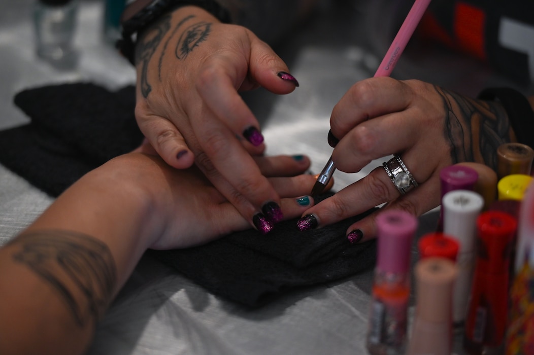 Lyn Orzech, cosmetologist, paints a military spouse’s nails at the Powell Event Center, Goodfellow Air Force Base, Texas, May 10, 2024. Free nail painting was one of many activities provided at the Military Spouse Resiliency & Wellness Day event. (U.S. Air Force photo by Airman 1st Class Brian Lummus)