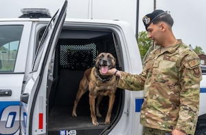 U.S. Air Force Staff Sgt. Marcel Durand, 509th Security Forces Squadron Military Working Dog handler and MWD Azir prepare to take Azir’s last ride at Whiteman Air Force Base, Mo., April 26, 2024. Durand and Azir worked several assignments including two United States Secret Service missions during their time at Whiteman AFB together. (U.S. Air Force photo by Senior Airman Hailey Farrell)