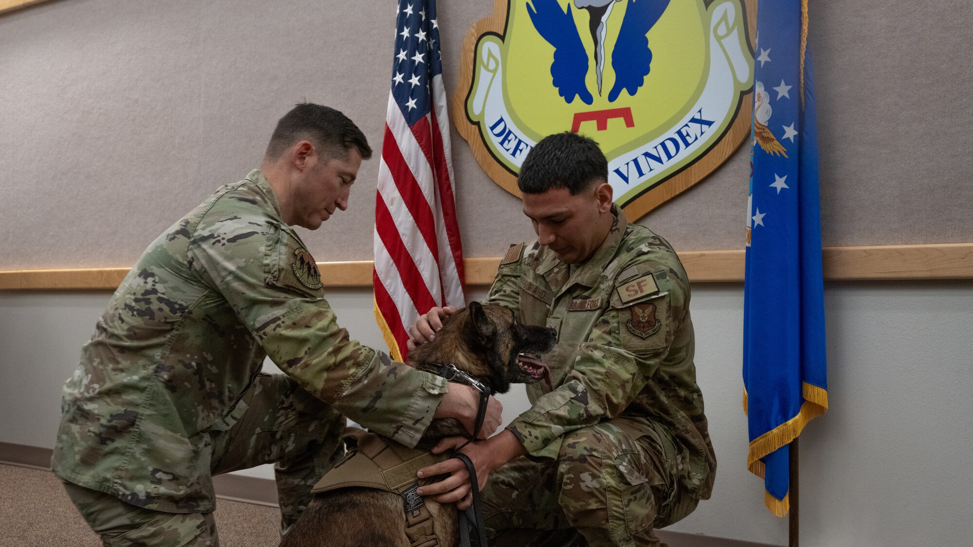 U.S. Air Force Lt. Col. Stephen Addington, 509th Security Forces Squadron commander and Staff Sgt. Marcel Durand, 509th SFS MWD handler, traded MWD Azir’s service collar to a civilian collar at Whiteman Air Force Base, Mo., April 26, 2024. The transfer of collar is a special conclusion of the military working dog retirement ceremony. (U.S. Air Force photo by Senior Airman Hailey Farrell)