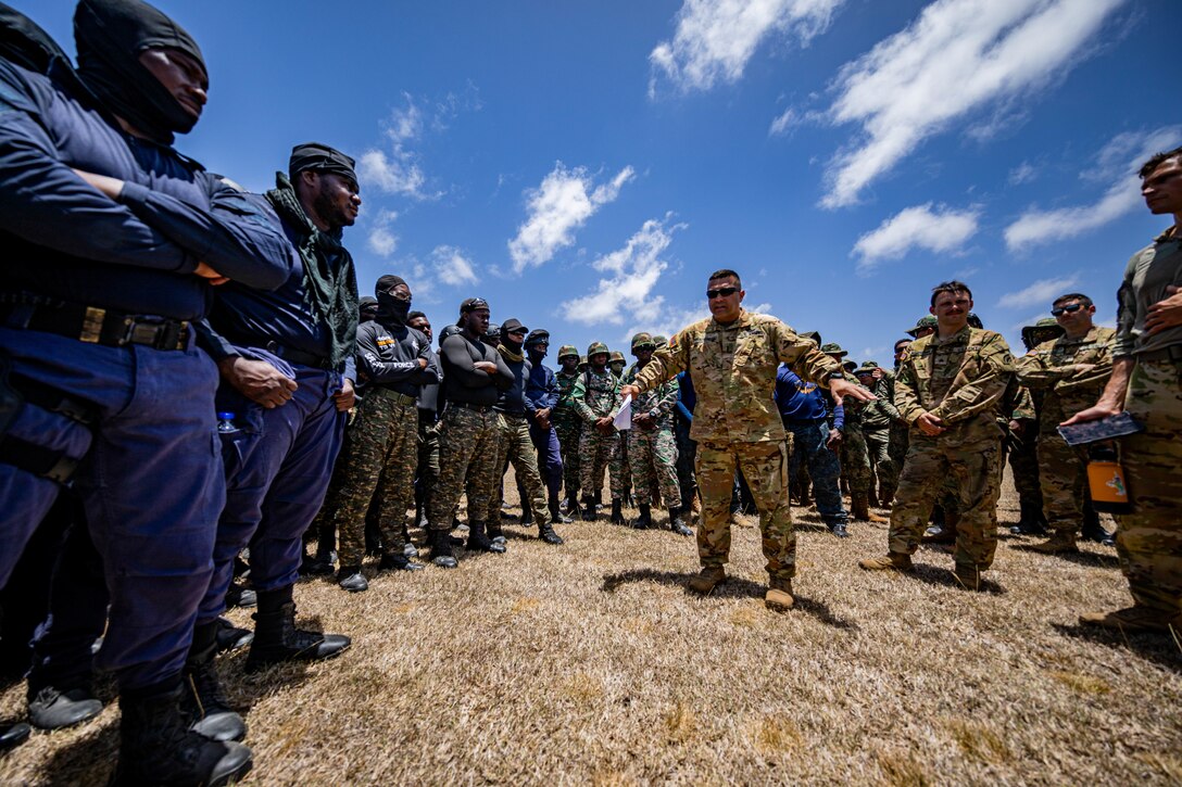 A New York Army National Guardsman provides a safety brief to service members and police officers from multiple nations.
